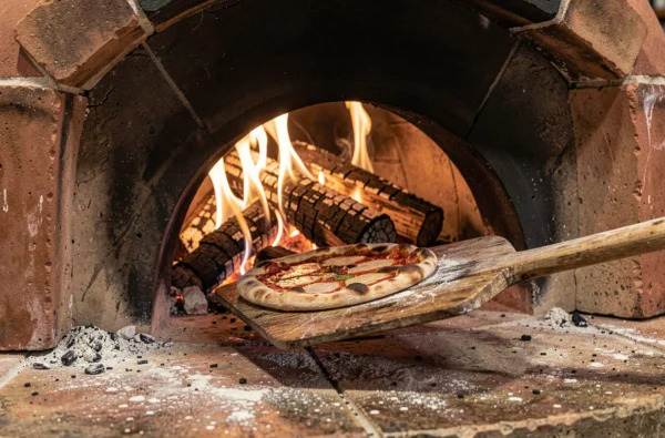 Four à bois traditionnel en plein fonctionnement avec pizzas cuites à la flamme chez Al Fornello à La Madeleine