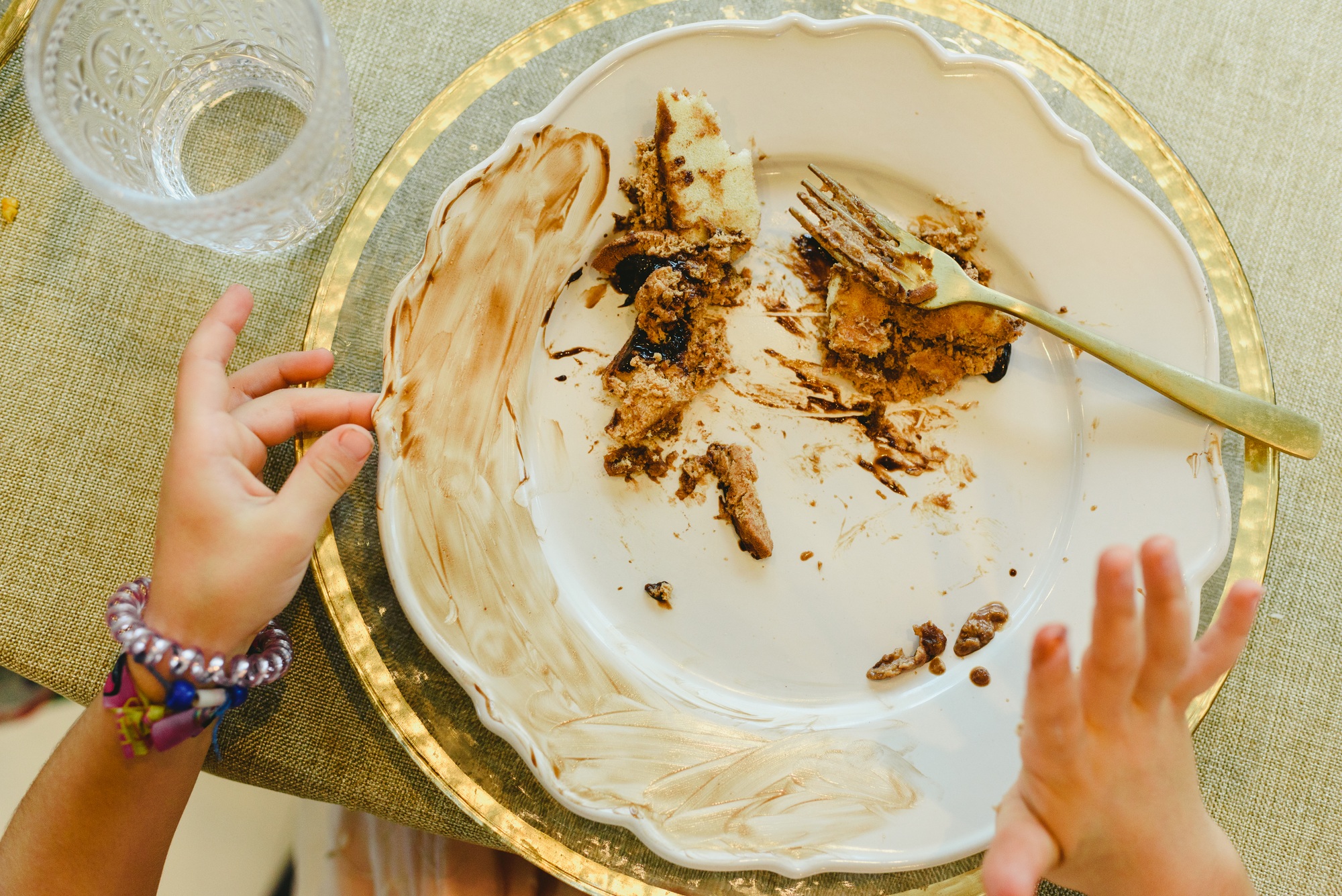 Elegant dish soiled and finished with child's hands finishing eating.