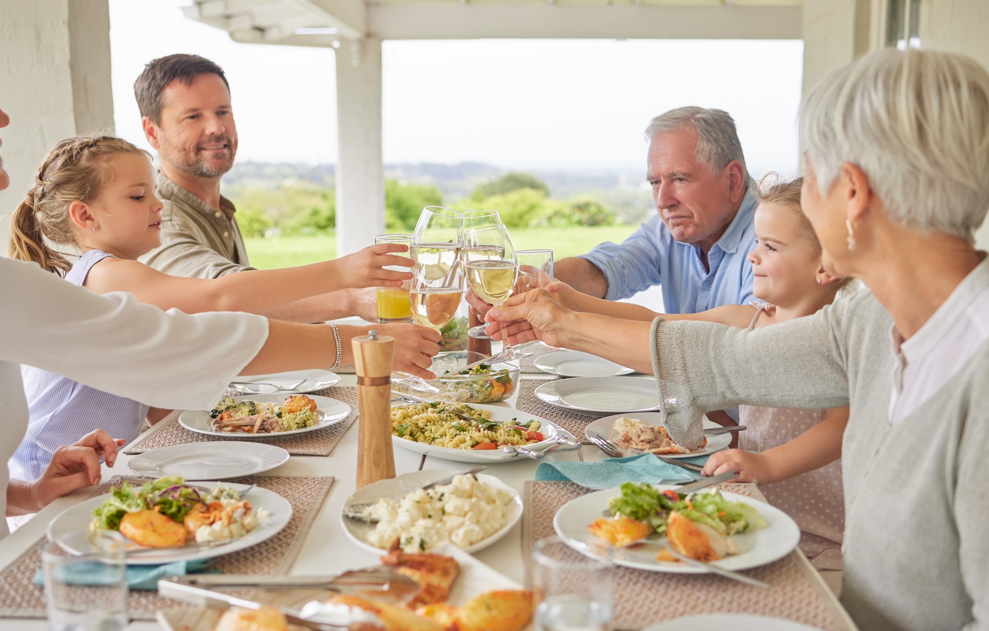 Heres to more life. Shot of a family toasting during a sunday lunch.